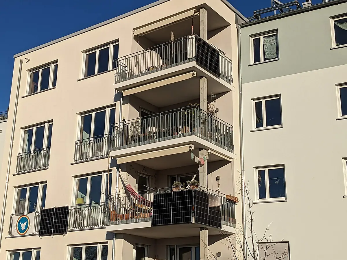 Apartment block with plug-in solar modules fixed to the outside of balcony railings on two floors