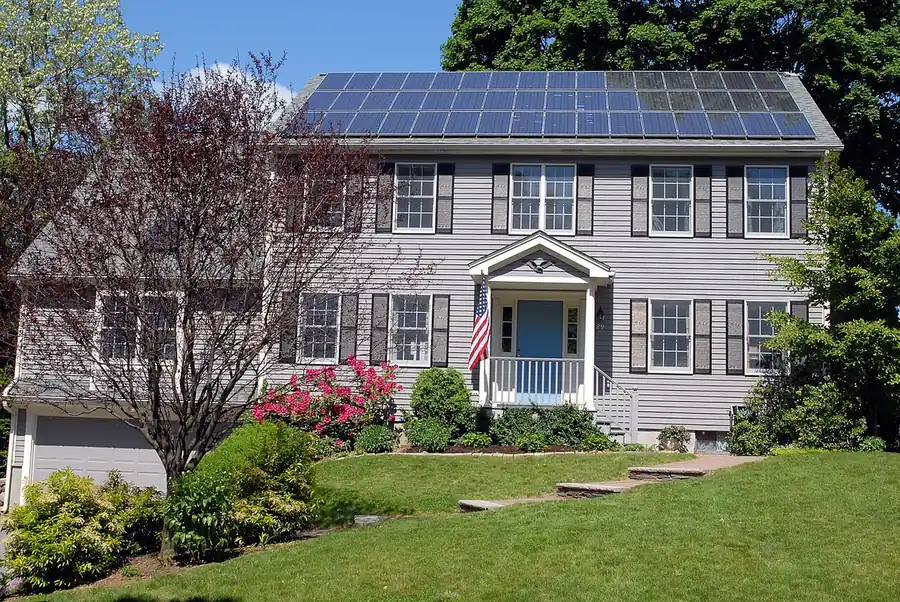 Two-storey house with an array of solar modules, about three rows deep, across the upper roof slope