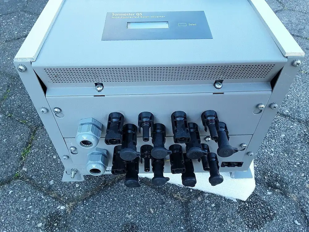 Underside of a solar inverter with four pairs of MC4 string input connectors and two cable glands