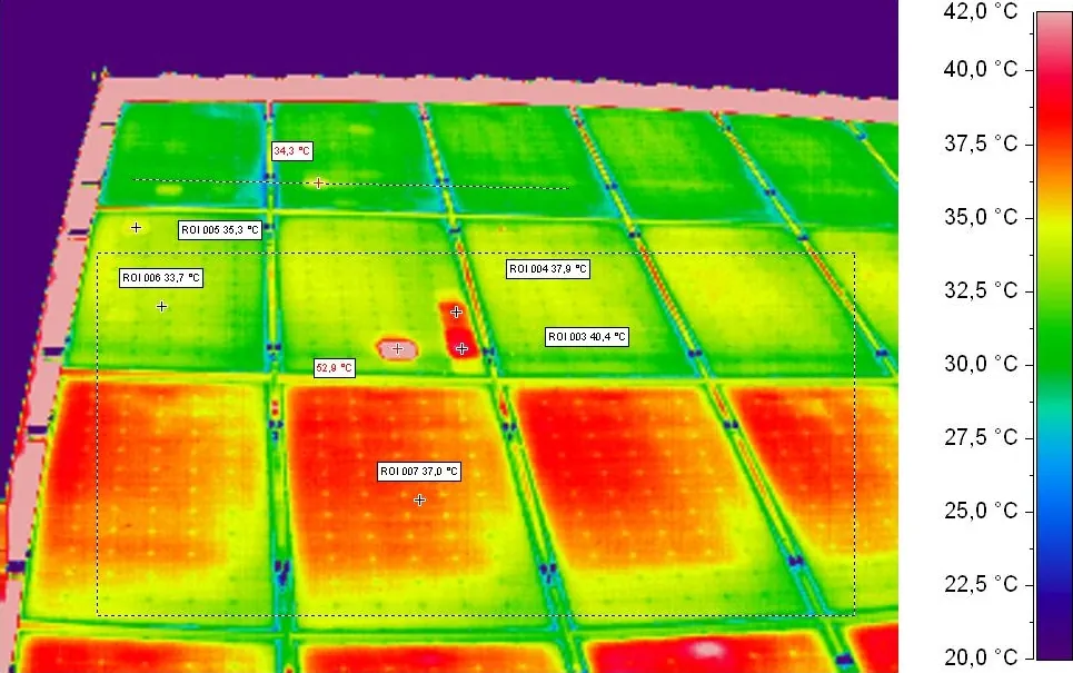 Infrared image of a solar array with a 20 to 42 degree scale and two cells glowing hotter
